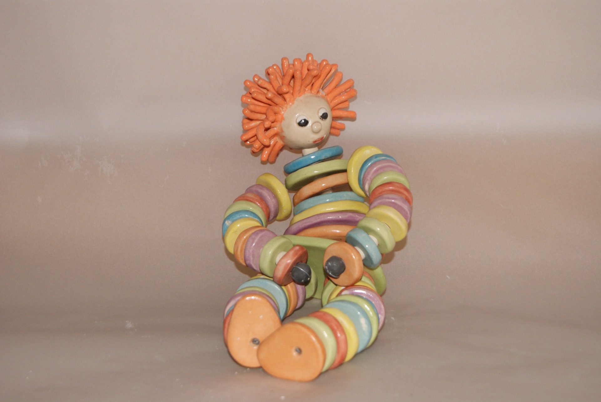 Vrolijke keramische pop van gekleurde ringen